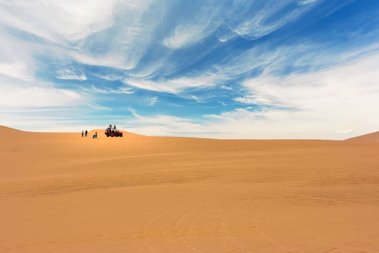 Distant view of people on desert against clear sky