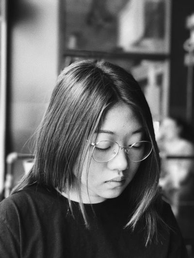 Close-up of woman wearing eyeglasses while sitting at handlebar restaurant