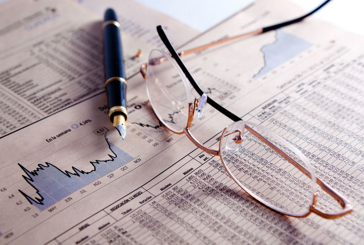 Financial and statistical background with graphics,glasses and pen