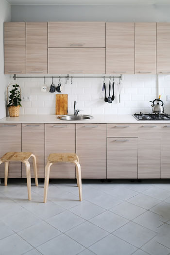 Bright kitchen set with stainless steel sink and facades with wood texture