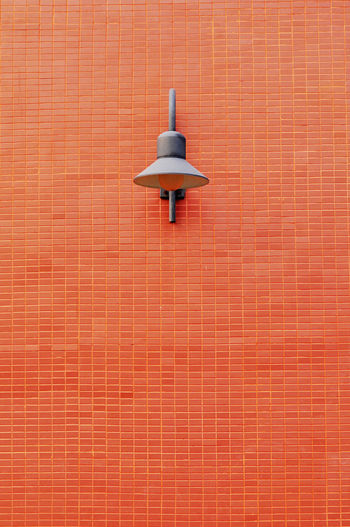 Low angle view of lamp on brick wall