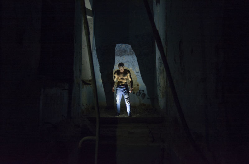 Shirtless man standing in darkroom