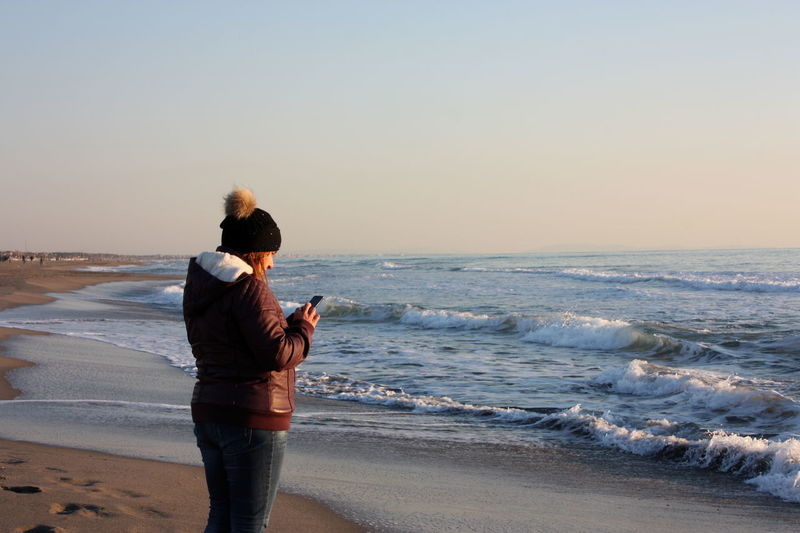 Relaxing walks on the sandy beach of versilia on a sunny day in italian winter