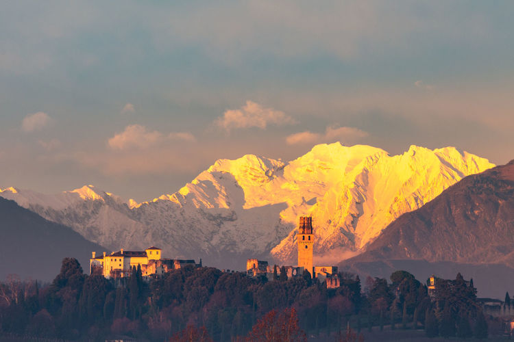 Panoramic view of buildings and mountains against sky during sunset