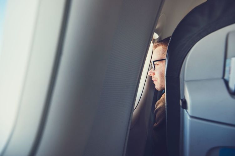 Man looking through airplane window