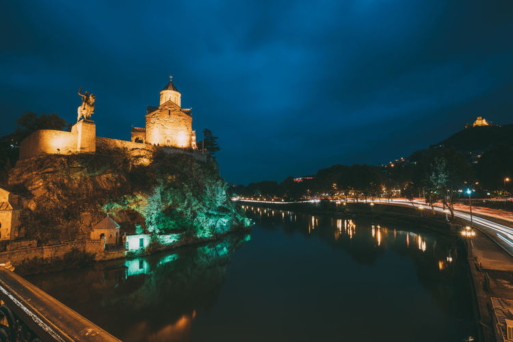 Illuminated historic buildings on mountain at night