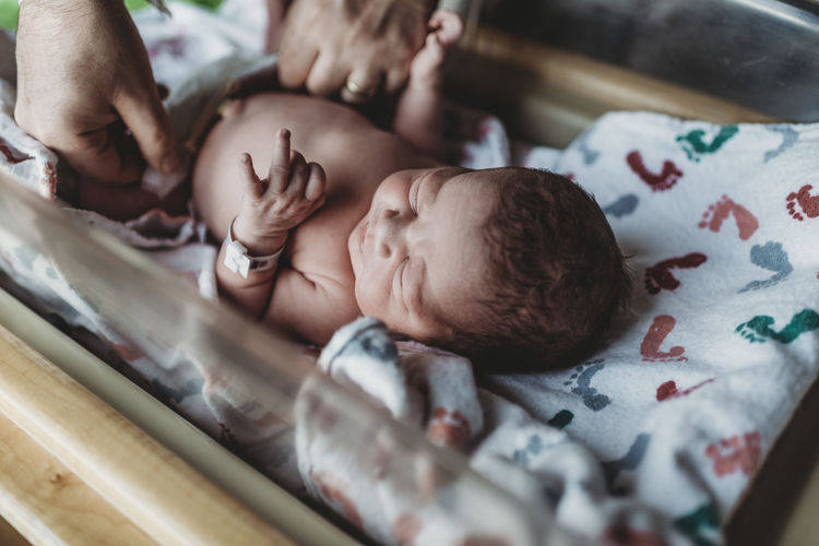 Newborn boy having diaper changed in hospital