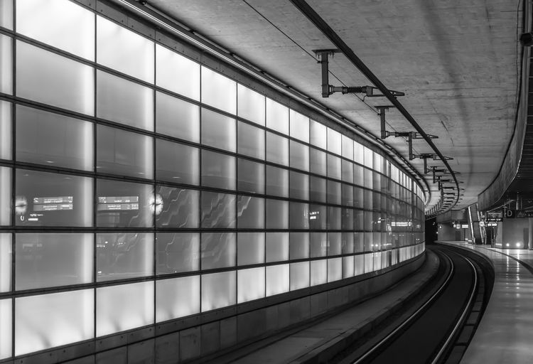 Empty railroad platform at illuminated subway station