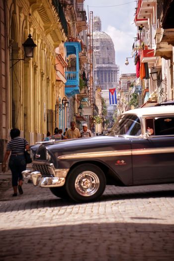 Vintage car on street against buildings in city