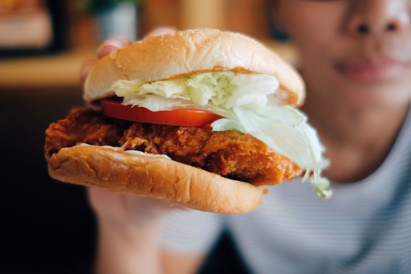 Close-up of woman holding fresh hamburger