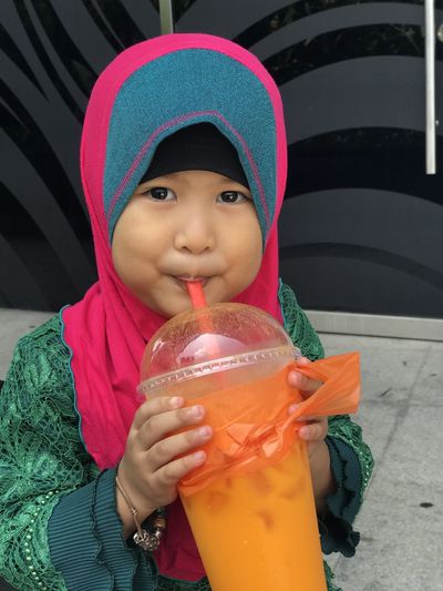 Portrait of cute girl drinking juice