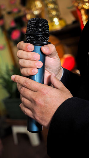 Male singer holding a wireless microphone during public performance