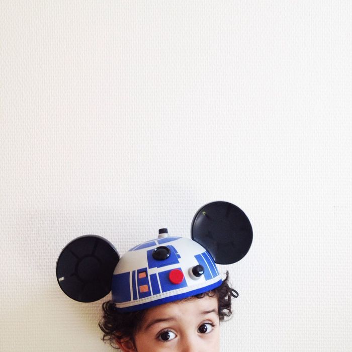 Portrait of boy wearing cartoon hat against wall at home