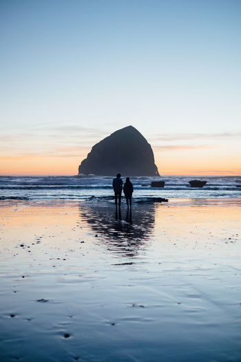 Silhouette couple overlooking calm sea
