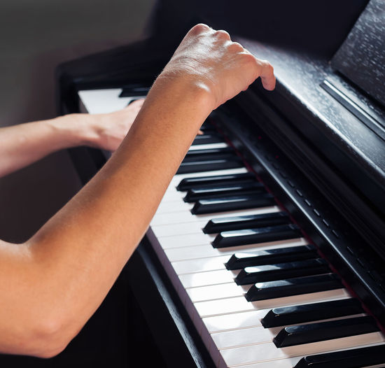 Midsection of person playing piano