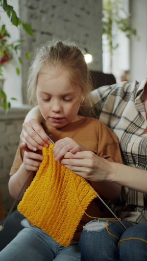Mother teaching crocheting to daughter