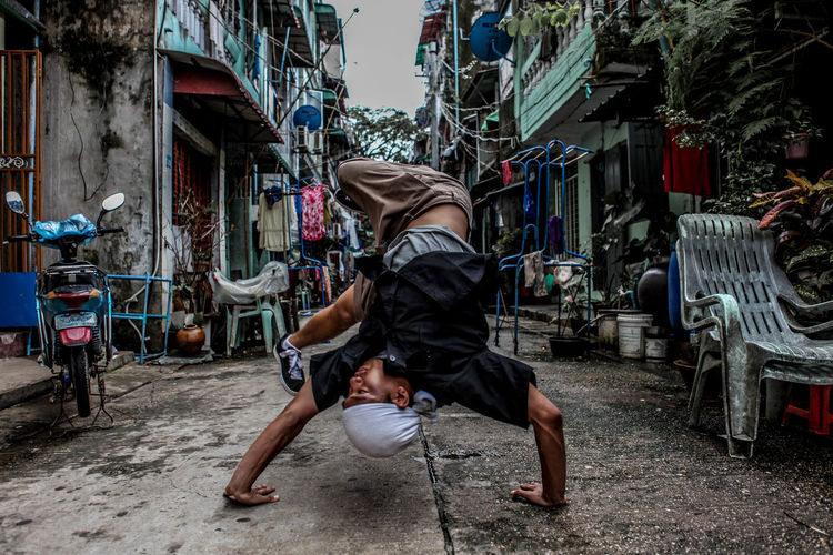 Rear view of man breakdancing on road