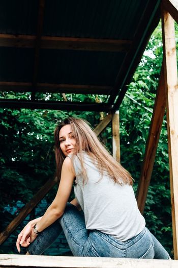 Portrait of smiling young woman sitting outdoors