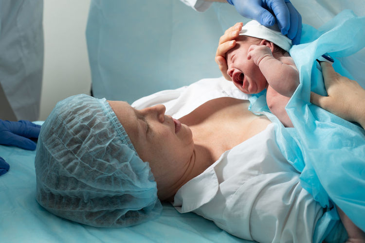 Woman holding newborn baby at hospital