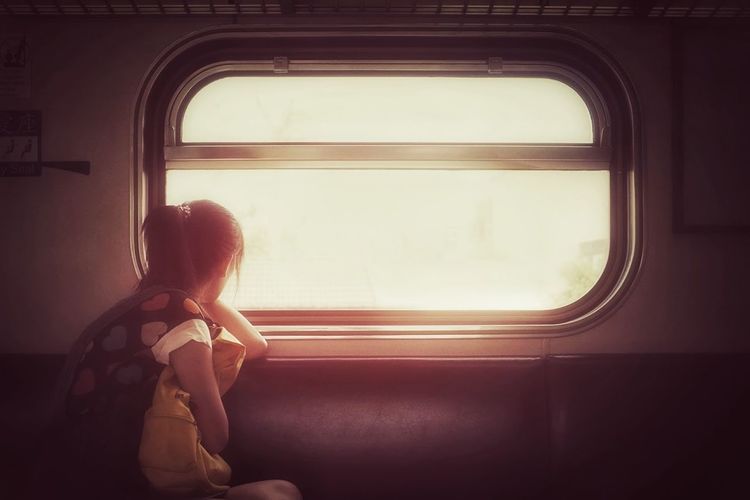Woman sitting by window in train