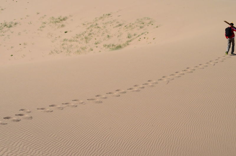 Footprints of man walking on sand dune in desert
