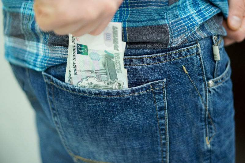 Midsection of man keeping money in pocket