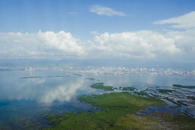 Aerial view of sea and land against sky