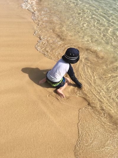 High angle view of boy playing at shore