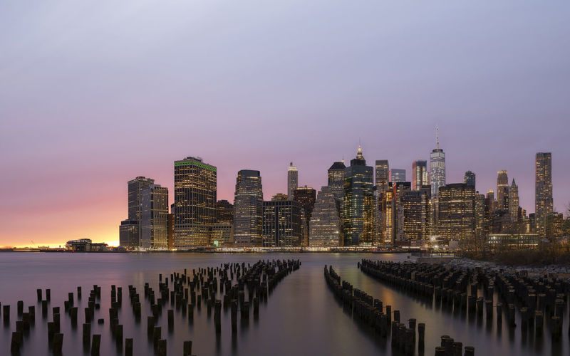 Panoramic view of sea and modern buildings against sky during sunset