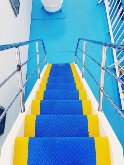 High angle view of yellow steps by swimming pool