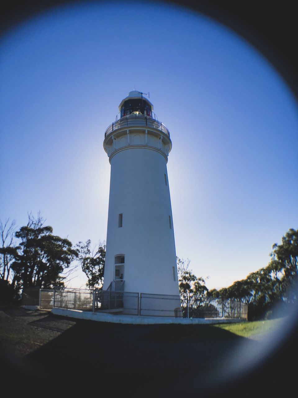 LOW ANGLE VIEW OF LIGHTHOUSE BY BUILDING AGAINST SKY