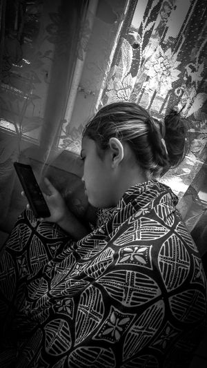 Side view of boy using mobile phone at home
