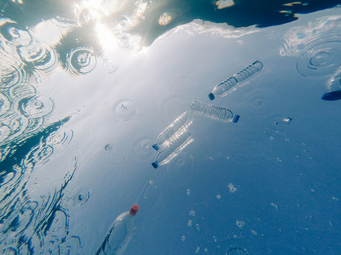 High angle view of water bottles floating on sea
