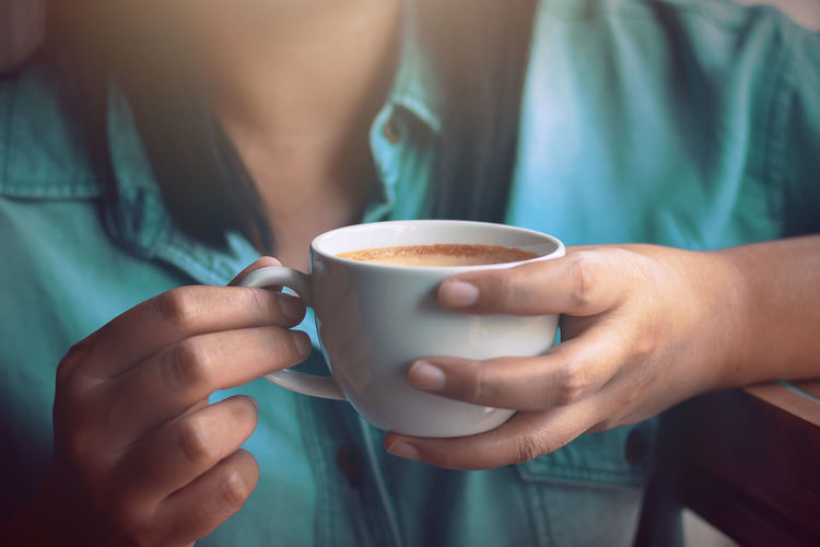 Close-up of hands holding coffee cup