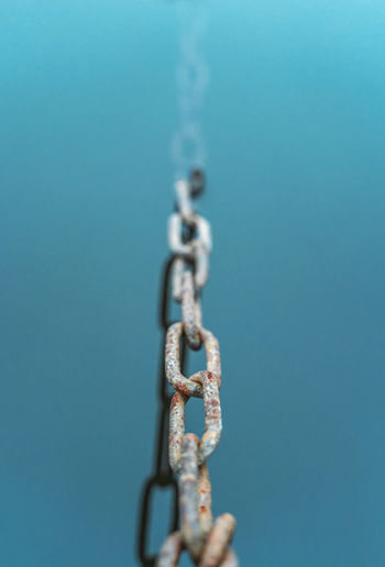 Close-up of chain against blue background