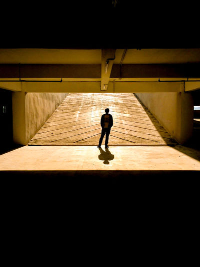 Rear view of silhouette man walking in corridor