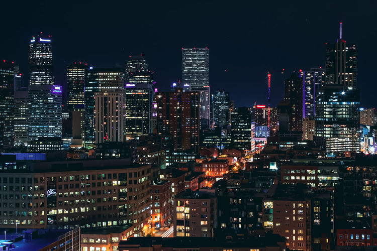 Illuminated buildings in city at night denver, co