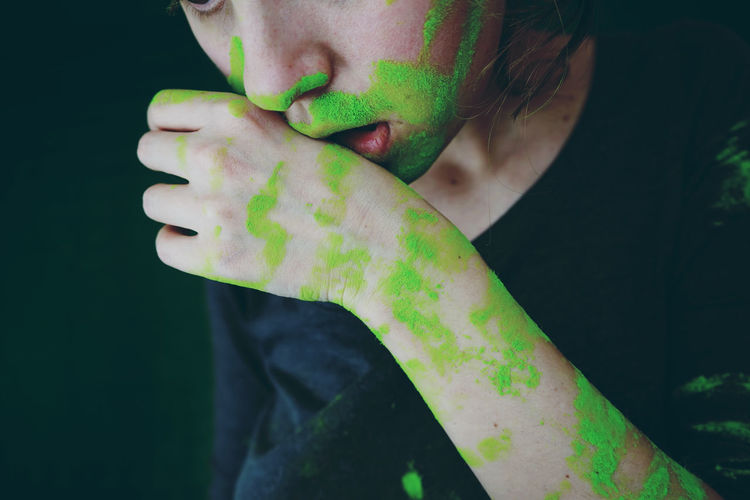 Close-up of midsection of woman with green powder paints