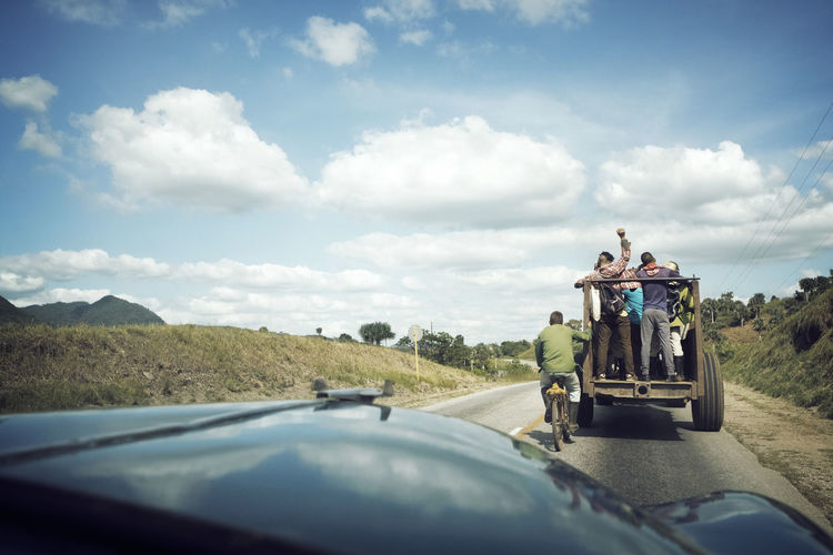 Rear view of male friends enjoying ride in vehicle