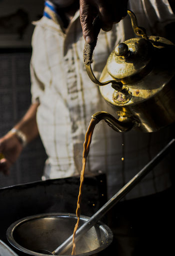 Person poring tea in a vessel