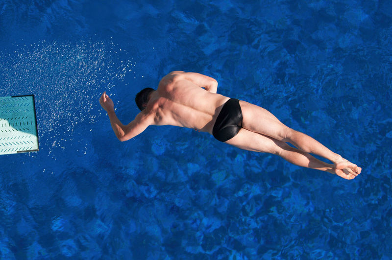 Directly above shot of man jumping in swimming pool