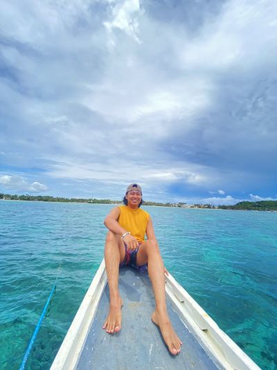 Low section of man jumping in sea against sky