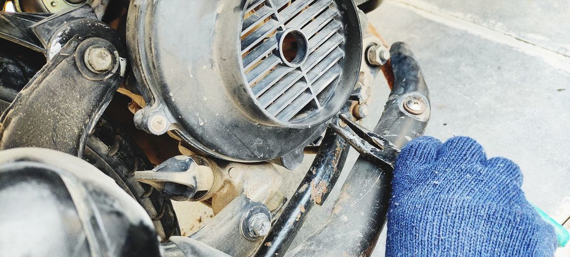 Cropped hand of mechanic repairing motor cycle