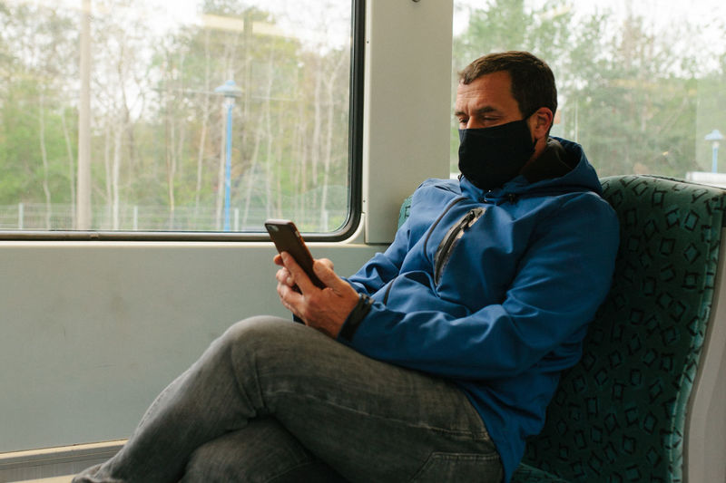 Man wearing mask while traveling in train