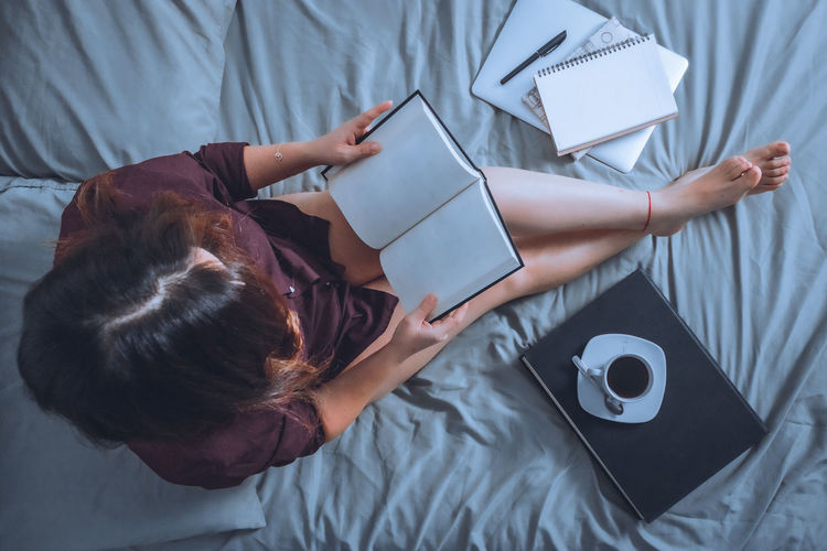 High angle view of woman lying on bed at home