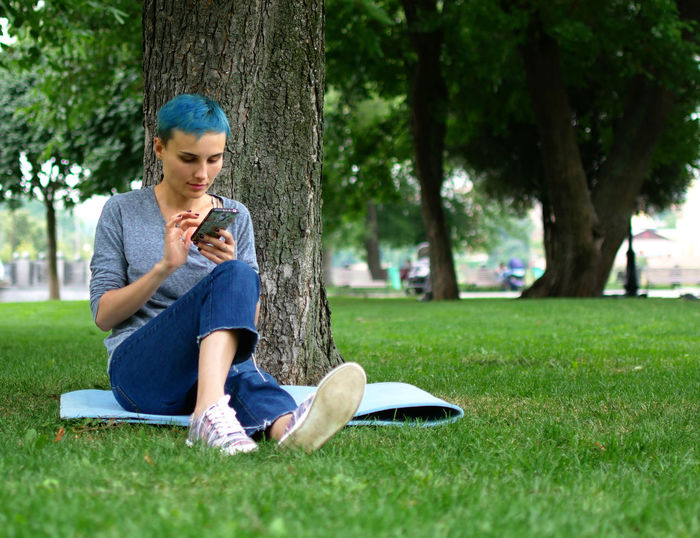 Teenage girl using mobile phone in park