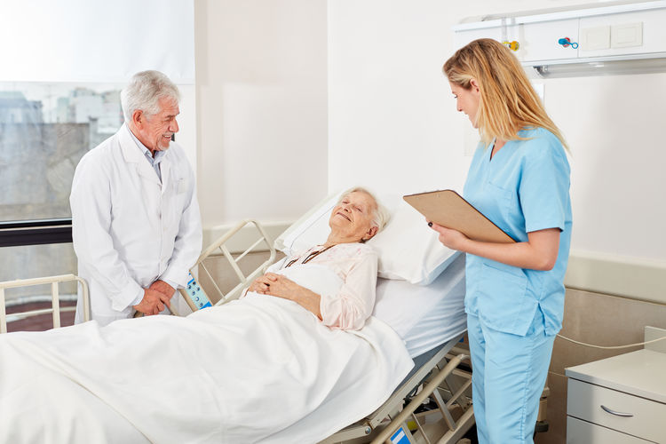 Doctors examining senior woman in hospital