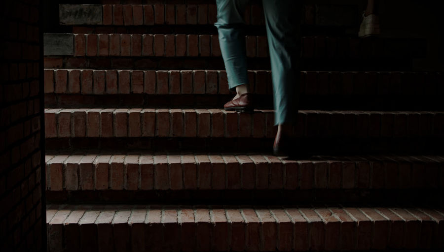 Low section of man walking on steps