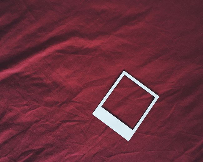 High angle view of instant print transfer on maroon sheet