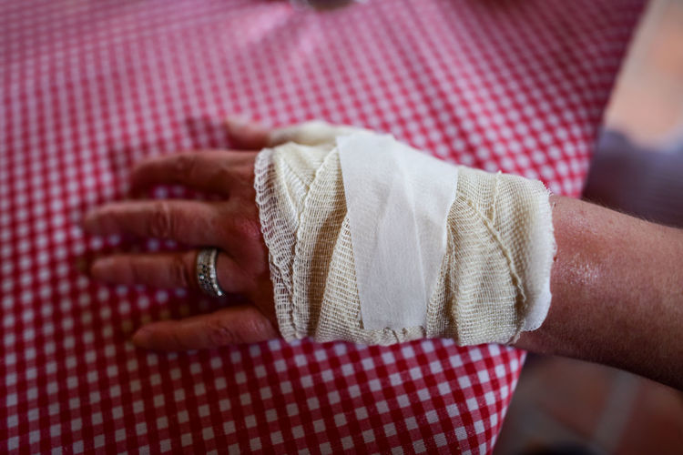 Close-up of woman hand with bandage on table